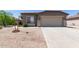 Inviting home featuring a two-car garage, desert landscaping, and a cozy, welcoming facade at 42347 W Bunker Dr, Maricopa, AZ 85138