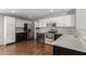 Bright kitchen with sleek stainless appliances, white and dark cabinets, and modern fixtures at 42347 W Bunker Dr, Maricopa, AZ 85138