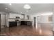 Open-concept kitchen featuring stainless appliances, dark wood floors, and abundant natural light at 42347 W Bunker Dr, Maricopa, AZ 85138