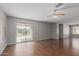 Light-filled living space with hardwood floors, sliding glass doors to the backyard, and a ceiling fan at 42347 W Bunker Dr, Maricopa, AZ 85138