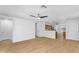 Open-concept living space with wood-look tile flooring, neutral walls, and a glimpse of the kitchen at 43787 W Colby Dr, Maricopa, AZ 85138