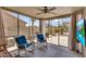 A relaxing screened-in patio with rocking chairs, offering a comfortable view of the backyard and desert landscaping at 43787 W Colby Dr, Maricopa, AZ 85138