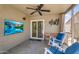 Comfortable screened-in patio featuring a ceiling fan and wall-mounted TV, perfect for outdoor entertaining at 43787 W Colby Dr, Maricopa, AZ 85138