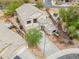 Aerial view showing the home's facade, desert landscaping, and three-car garage in a suburban neighborhood at 44890 W Desert Garden Rd, Maricopa, AZ 85139