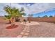 Landscaped backyard featuring a fire pit, palm trees and decorative rock at 44890 W Desert Garden Rd, Maricopa, AZ 85139