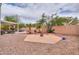 Expansive backyard with gravel, hardscape patio, and mature trees, ideal for outdoor activities at 44890 W Desert Garden Rd, Maricopa, AZ 85139