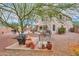 View of the home's backyard featuring mature trees, a patio, and a well-maintained landscape at 44890 W Desert Garden Rd, Maricopa, AZ 85139