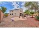 Large backyard showcasing the patio, gravel landscaping, and mature trees at 44890 W Desert Garden Rd, Maricopa, AZ 85139