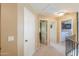 Hallway featuring carpeted floors, neutral walls, white doors, and access to laundry room at 44890 W Desert Garden Rd, Maricopa, AZ 85139