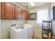 Well-lit laundry room with top-load washer and dryer and ample storage cabinets at 44890 W Desert Garden Rd, Maricopa, AZ 85139