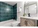 Modern bathroom with green tiled shower, bathtub, stylish wooden vanity, decorative mirror, and contemporary fixtures at 510 N Entrada St, Chandler, AZ 85226
