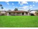 Expansive backyard featuring a covered patio area with seating, a well-maintained lawn, and privacy fencing at 6725 E Kings Ave, Scottsdale, AZ 85254