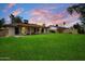 Expansive backyard featuring a covered patio area with seating, a well-maintained lawn, and privacy fencing at 6725 E Kings Ave, Scottsdale, AZ 85254