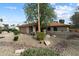 A well kept front yard with desert landscaping and mature trees leading to a single story home and two car garage at 6725 E Kings Ave, Scottsdale, AZ 85254