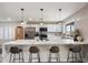 Kitchen island with white countertops, barstool seating, stylish pendant lights, and stainless appliances at 6725 E Kings Ave, Scottsdale, AZ 85254