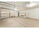 Spacious garage featuring concrete flooring, overhead lighting, shelving, and ample storage space at 7019 S 19Th Pl, Phoenix, AZ 85042