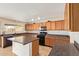Full kitchen view showcasing ample wood cabinets, countertops, and a convenient kitchen island with barstool seating at 7019 S 19Th Pl, Phoenix, AZ 85042