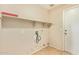 Bright laundry room with tile flooring, shelving, washer and dryer hookups, and exterior access at 7019 S 19Th Pl, Phoenix, AZ 85042