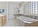 Spa-like bathroom with a soaking tub, a glass-enclosed shower, and designer tile work at 7262 E Lupine Ave, Scottsdale, AZ 85260
