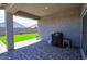 Covered back patio featuring pavers, synthetic grass, and a BBQ, perfect for outdoor enjoyment at 7751 W Miami St, Phoenix, AZ 85043