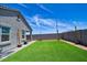 Green backyard with synthetic grass, pavers, string lights, and a sturdy block wall for added privacy at 7751 W Miami St, Phoenix, AZ 85043