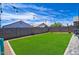 Backyard featuring a lush synthetic grass lawn, pavers, block wall, and string lights, ideal for entertaining at 7751 W Miami St, Phoenix, AZ 85043