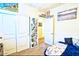 Bright bedroom featuring neutral walls, carpeted flooring, closet, and decorated with colorful stickers and images at 7751 W Miami St, Phoenix, AZ 85043
