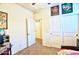 Neutral bedroom with carpet, ceiling fan, and closet, featuring colorful artwork and door leading to hallway at 7751 W Miami St, Phoenix, AZ 85043