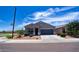 Well-manicured lawn and tidy landscaping complement this cozy single-level home with an attached garage at 7751 W Miami St, Phoenix, AZ 85043