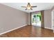 Cozy bedroom featuring wood floors, a ceiling fan, and glass doors leading to the yard at 8140 E Mitchell Dr, Scottsdale, AZ 85251
