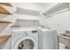 Functional laundry room with a washing machine, dryer, a stainless steel sink, and shelving at 8140 E Mitchell Dr, Scottsdale, AZ 85251