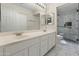 Bathroom featuring double sink vanity, large mirror, and updated glass enclosed shower at 9231 W Grovers Ave, Peoria, AZ 85382