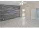Aesthetic bedroom featuring stylish plank accent wall, ceiling fan, and marble-look tile flooring at 9231 W Grovers Ave, Peoria, AZ 85382