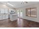 Bright kitchen with stainless steel appliances, white cabinets, island, and doors to the backyard at 9231 W Grovers Ave, Peoria, AZ 85382