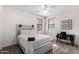 Bedroom with a whitewashed headboard, wood blinds, ceiling fan, and a modern-style desk with a black office chair at 9622 S 46Th Ln, Laveen, AZ 85339