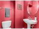Cozy powder room with vibrant red walls, a modern toilet, and a unique vanity at 9622 S 46Th Ln, Laveen, AZ 85339