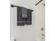 Close-up of a shower with dark towels hanging on a black towel bar with chrome fixtures and a white shower surround at 9622 S 46Th Ln, Laveen, AZ 85339