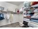Organized walk-in closet with shelves stacked with linens, blankets and towels, with wood grain laminate flooring at 9622 S 46Th Ln, Laveen, AZ 85339
