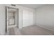 Bedroom with neutral carpet, closet with white sliding doors and adjoining laundry room at 9990 N Scottsdale Rd # 2029, Paradise Valley, AZ 85253