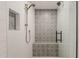 Modern shower featuring decorative tiles, a built-in bench, and glass enclosure at 1003 E Marigold Ln, Tempe, AZ 85288