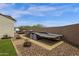 Spacious backyard area featuring a trailer, landscaping, and privacy wall, perfect for outdoor storage at 11334 S 52Nd Ln, Laveen, AZ 85339