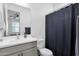 Bright bathroom featuring modern fixtures, a vanity, toilet and shower with blue curtain at 11334 S 52Nd Ln, Laveen, AZ 85339