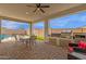 Outdoor covered patio with dining table, built in grill, and ample seating area for entertaining guests at 11334 S 52Nd Ln, Laveen, AZ 85339