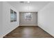 Bright and airy dining room showcasing hardwood floors, modern light fixture, and large window for natural light at 11334 S 52Nd Ln, Laveen, AZ 85339