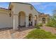 The entryway of this stucco home has a covered porch and brick pavers at 11334 S 52Nd Ln, Laveen, AZ 85339