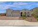 Charming home featuring a three-car garage, brick driveway and covered entry with appealing archways at 11334 S 52Nd Ln, Laveen, AZ 85339