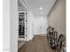 Hallway featuring wood-look tile flooring, a modern console table, pantry and wagon wheel at 11334 S 52Nd Ln, Laveen, AZ 85339