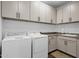 Well-organized laundry room featuring modern washer and dryer, sink, cabinets, and countertop space at 11334 S 52Nd Ln, Laveen, AZ 85339