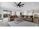 An inviting living room with modern fan, neutral tones, stylish furniture, and seamless indoor-outdoor flow at 11334 S 52Nd Ln, Laveen, AZ 85339