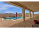 Inviting pool area with lounge chairs, umbrellas, and covered patio for relaxation at 11334 S 52Nd Ln, Laveen, AZ 85339